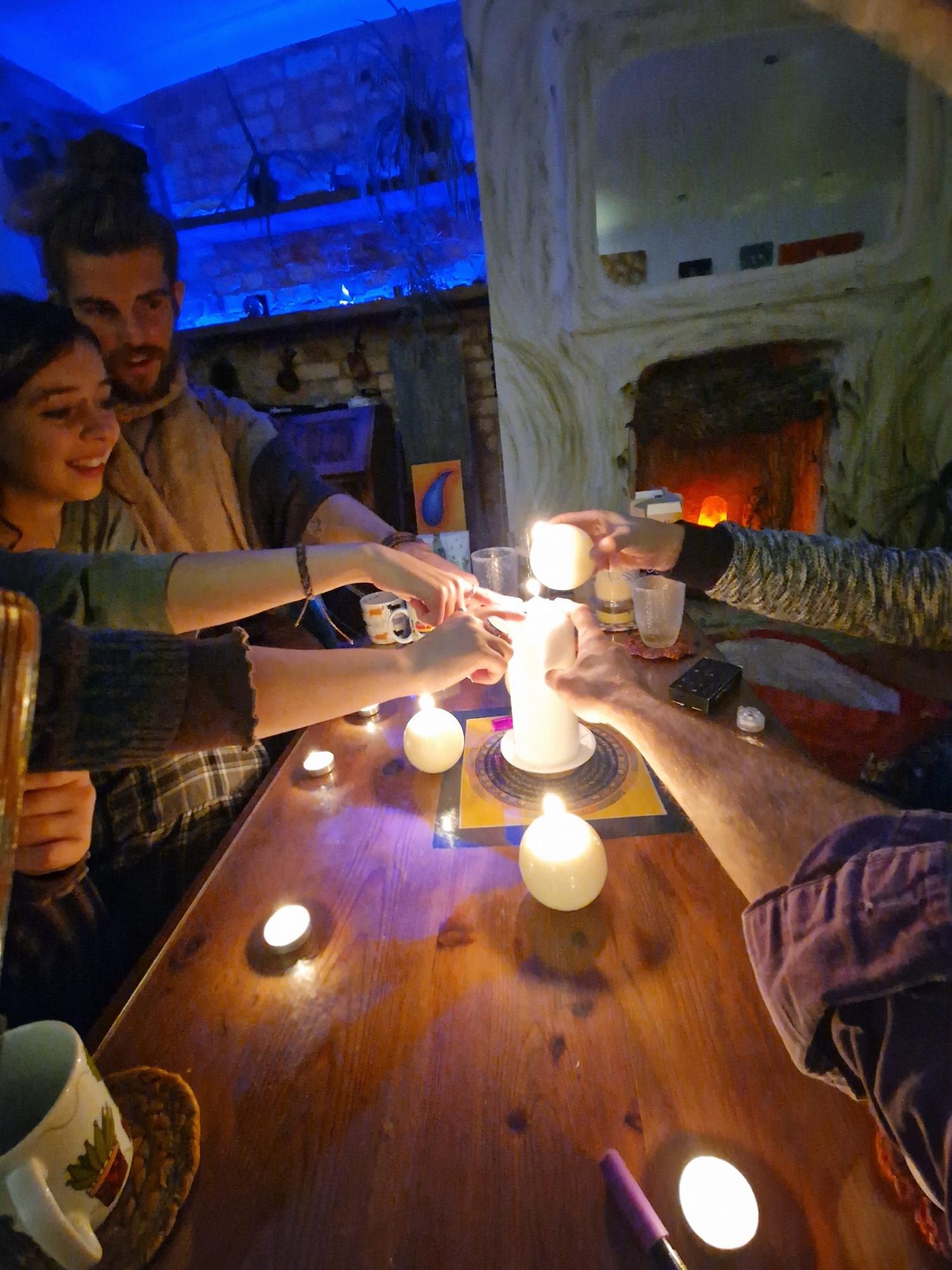 Hands reaching in together to light a candle