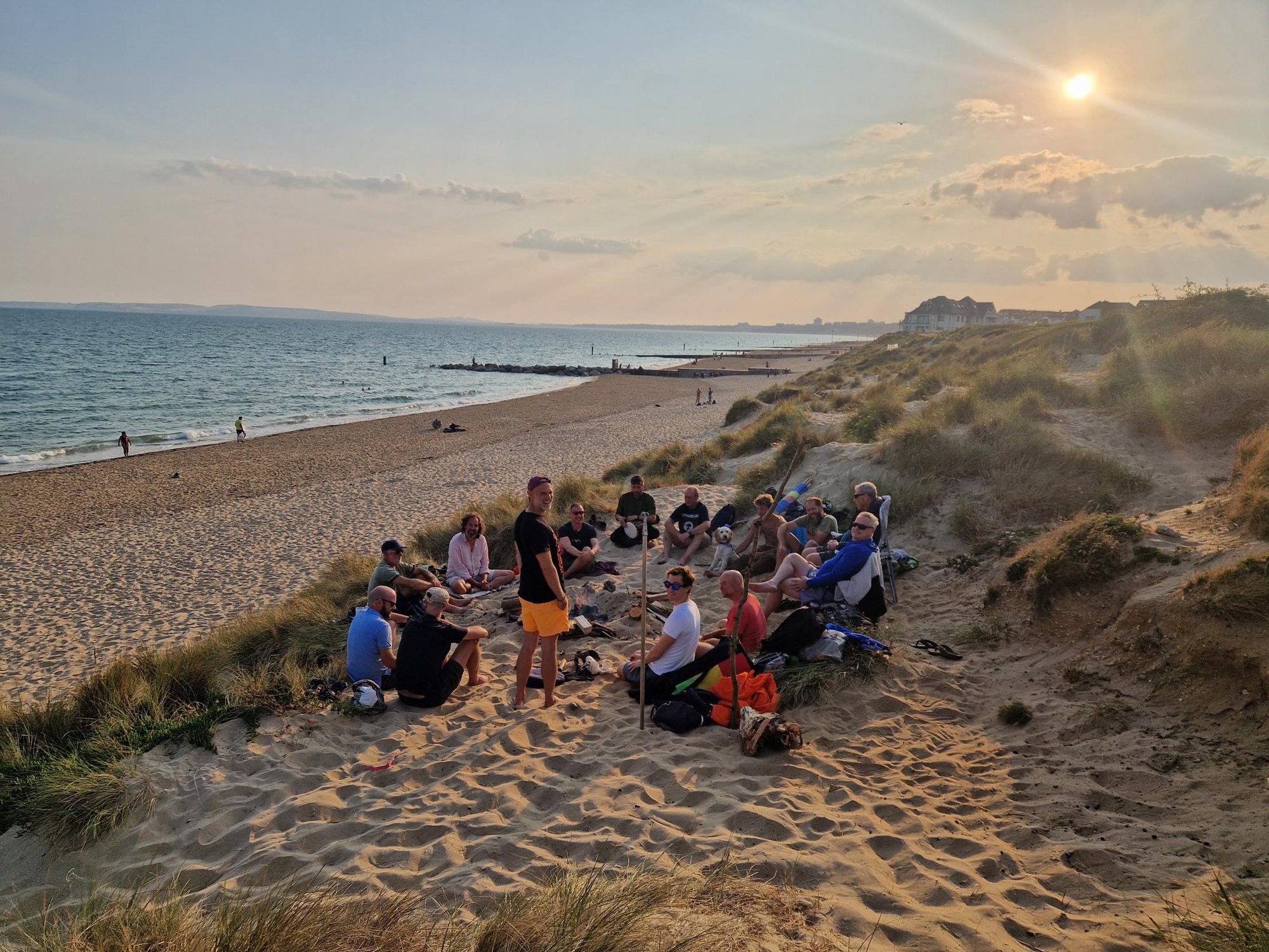 The Dorset Men's Circle in the dunes at sunset, a small fire at the centre
