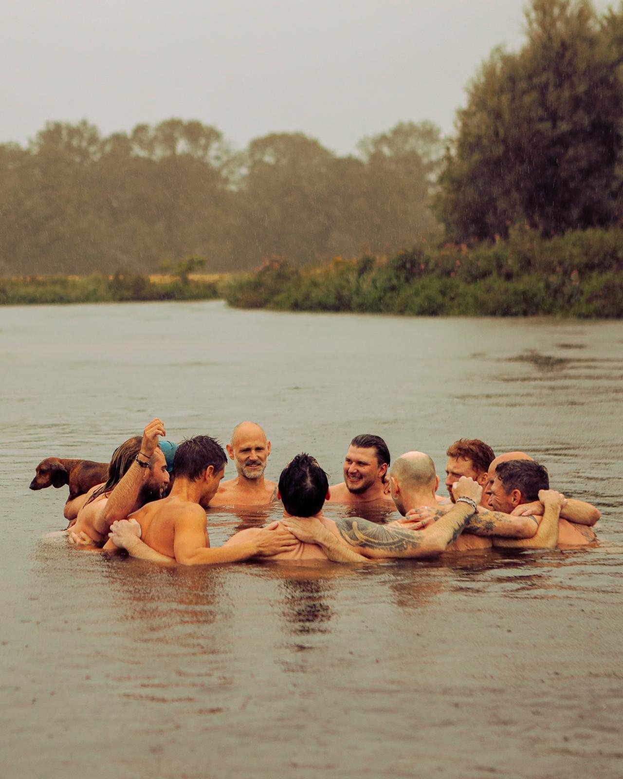 The circle in the river in the rain, arms around each other