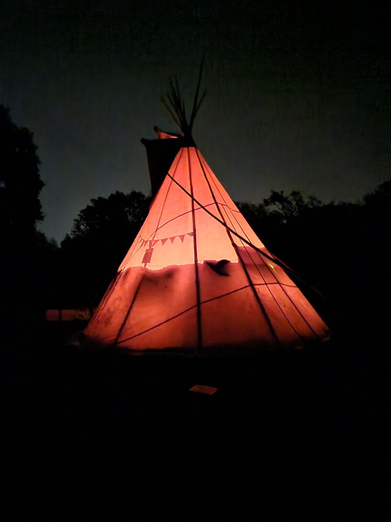 The tipi glowing at night